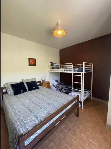 a bedroom with a bed and two bunk beds at Chambres du Causse in Saint-Cernin-de-Larche