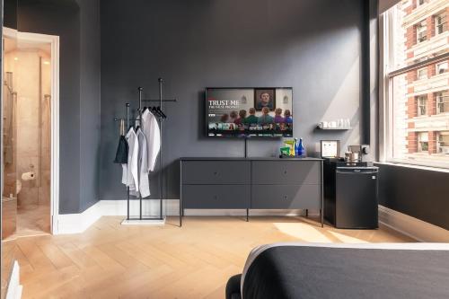 a bedroom with a television on a black wall at Madison Square Studio at Return Policy Broadway in New York