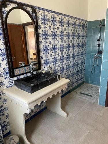 a bathroom with a sink and a mirror at maison rachid in El Guecheïne