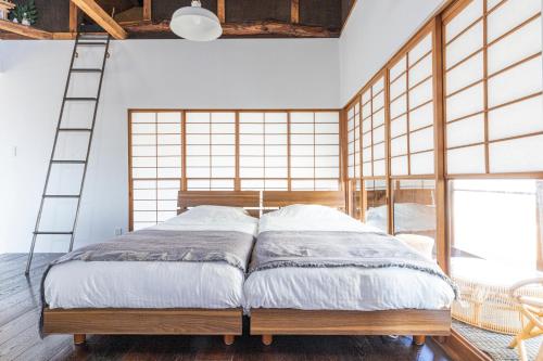 a bedroom with a bed with a ladder in it at Takeno-an in Mitaka