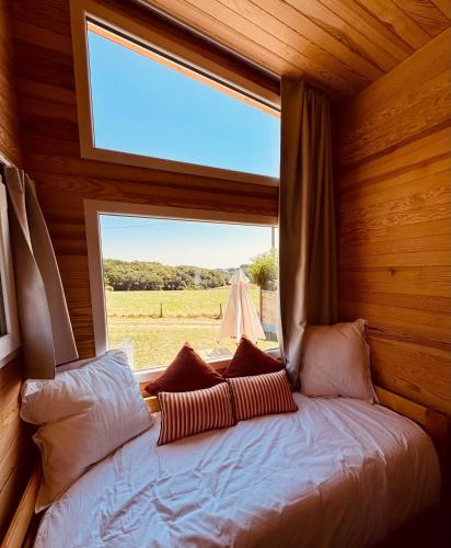 a bed in a room with a large window at l'échappée verte in Anvéville