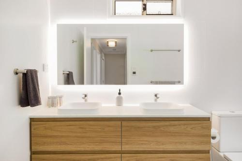 a bathroom with two sinks and a mirror at Seaside Escape in Tathra