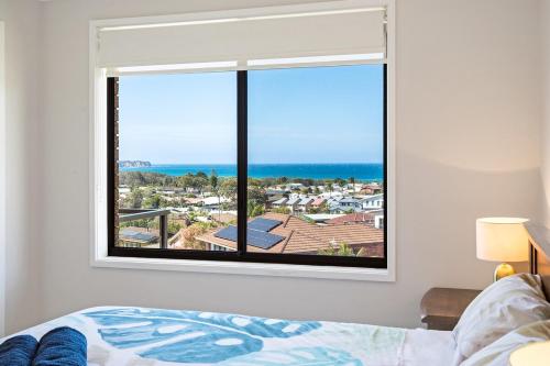 a bedroom with a window with a view of the ocean at Seaside Escape in Tathra