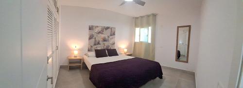 a bedroom with a bed and two tables and a window at La OSTRA 33 in Chiclana de la Frontera
