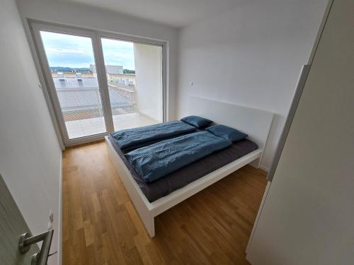 a bedroom with a bed and a large window at Apartma Tri Srca Radenci 3 sobe in Radenci