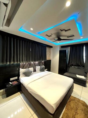 a bedroom with a large bed with a blue light at Hotel prime View in Ahmedabad