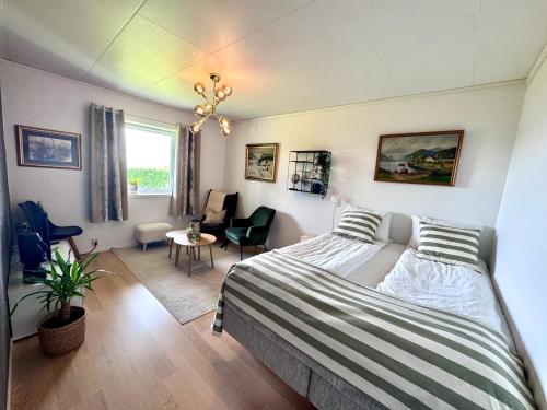 a bedroom with a bed and a living room at Appartment with garden and a big bathroom in Malvik