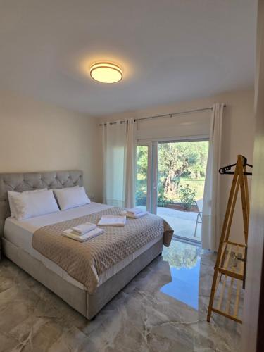 a bedroom with a bed and a large window at BLV Apartments in Tsoukalades