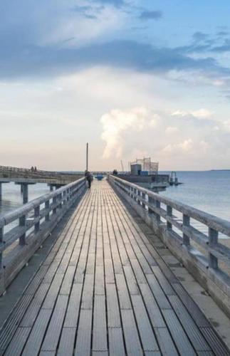 a wooden pier stretches out into the water at Gästehaus am Binnensee in Heiligenhafen