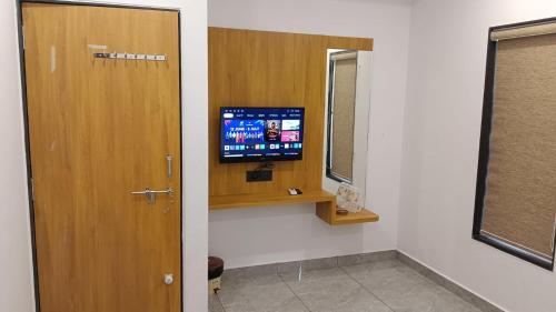 a room with a door and a television on a wall at Hotel Dwarkesh in Dwarka