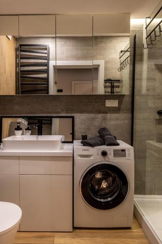 a kitchen with a washing machine and a sink at THE LOFT - Garncarska 1 in Piotrków Trybunalski
