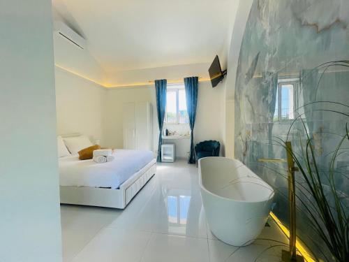a white room with a bed and a bath tub at Zagara Suite in Francofonte