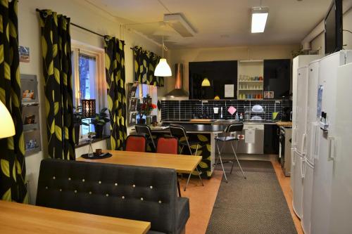sala de estar con mesa y cocina en Södra Bergets Vandrarhem, en Sundsvall
