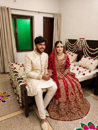 a bride and groom are sitting on a bench at Timber Box Hostels in Rawalpindi