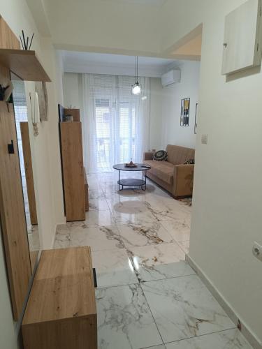 a living room with a table and a couch at Cloud9 Apartment in Kavála
