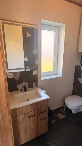 a bathroom with a sink and a window and a toilet at Domki letniskowe Hamer in Łeba