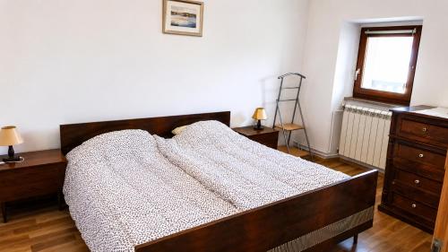 a bedroom with a bed and a dresser and a window at Hisa pri Ovcicevih in Komen