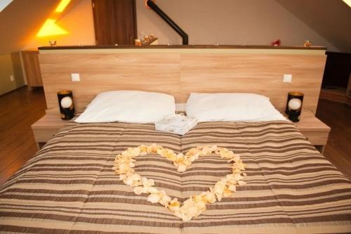 a bed with a heart made out of pillows at Hotel Vinohrad in Milotice