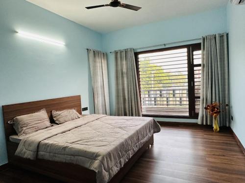 a bedroom with a bed and a large window at Comfy Corner in Chandīgarh