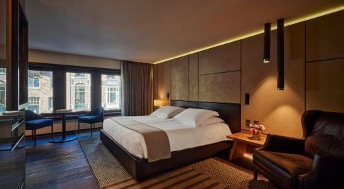 a hotel room with a bed and a desk at Mandarin Oriental Conservatorium, Amsterdam in Amsterdam