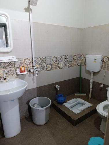 a bathroom with a toilet and a sink and a toilet istg at Alnoor Lodgings in Rabwāh