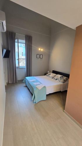 a bedroom with a large bed and a window at Casa Vacanza Palazzo Monacelli 1 in Torre del Greco