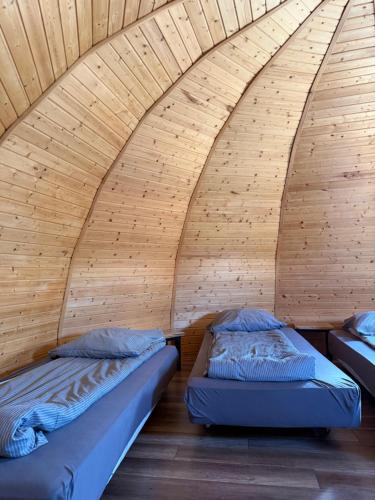 two beds in a room with wooden walls at Agroturystyka Rajski Ogród in Mysłakowice