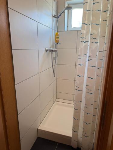 a shower stall with a shower curtain with fish on it at Lorenzo Apartments 05 in Burglengenfeld