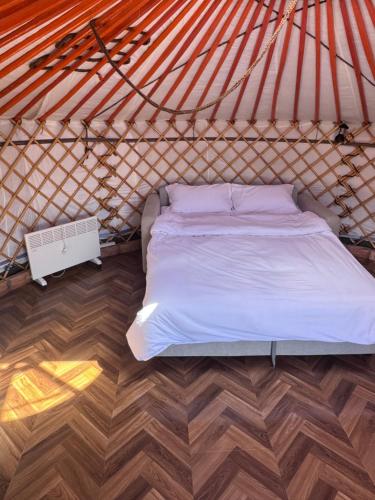 a bed in a yurt with a wooden floor at Mongolian traditional house Ger in Dzuunmod