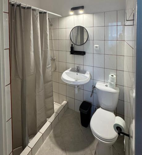 a bathroom with a toilet and a sink and a mirror at Pomarańczowy Domek in Junoszyno