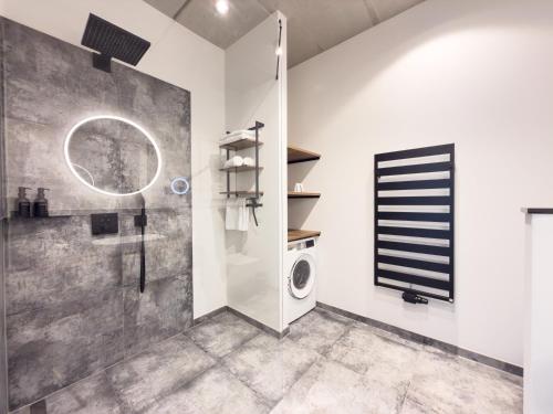a bathroom with a shower and a washing machine at ELBE6 Apartments in Wittenberge