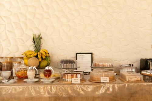 a buffet with fruit and other food items on a table at Pousada Tropical Ilhas in Aquiraz