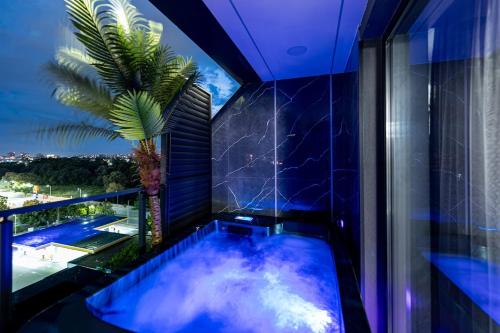 a jacuzzi tub in a balcony with a palm tree at Beni Deluxe 2 in Plovdiv