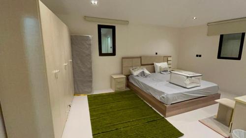 a bedroom with a bed and a green rug at شاليه الكوثر in Al Baha
