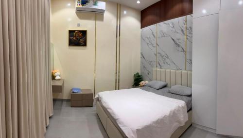 a bedroom with a bed and a wall at JebelStay in Al Ḩamrāʼ