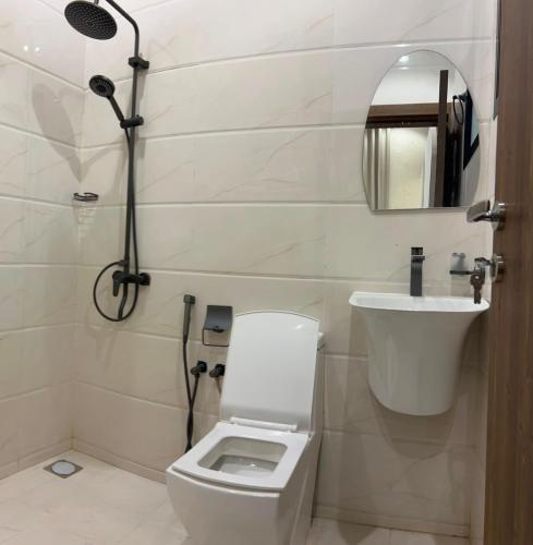 a bathroom with a toilet and a sink and a shower at JebelStay in Al Ḩamrāʼ