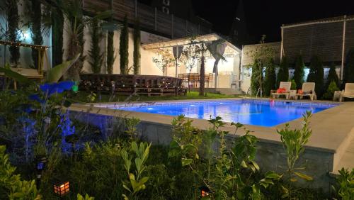 a swimming pool in a yard at night at Qafqaz Mountside Chalet in Gabala