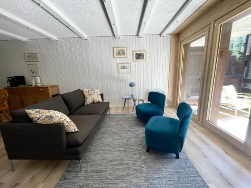 a living room with a couch and two chairs at Appart La Fouly in La Fouly