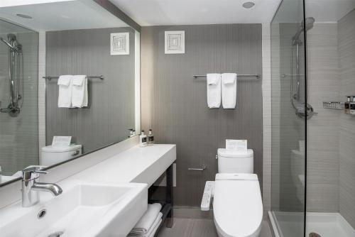 a bathroom with a sink and a toilet and a shower at Coast Prince George Hotel in Prince George