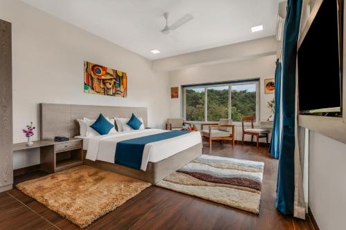 a bedroom with a large bed and a dining room at Nivaara by GHD Hotels in Nerul