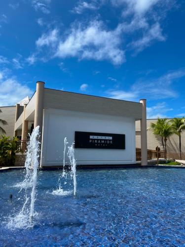 a large building with a fountain in front of it at Pirâmide Palace Hotel in Natal
