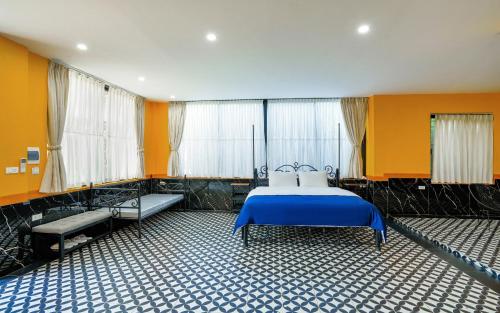 a bedroom with a blue bed and yellow walls at De Mémoire Retreat in Tien Xuan