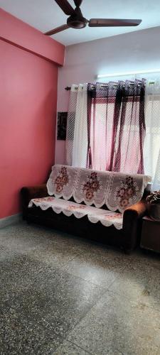 a bed in a room with a pink wall at Anand Vihar in kolkata