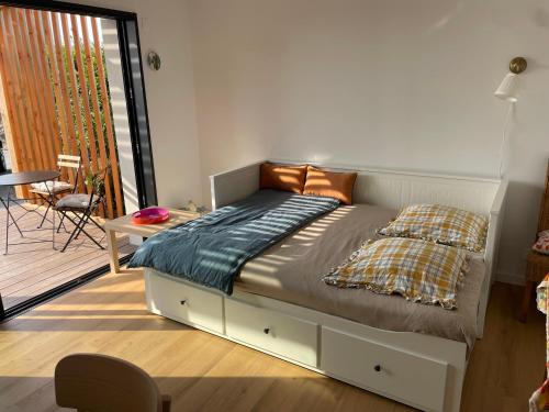 a bedroom with a bed and a table and a balcony at Appartement bord de mer in Lampaul-Plouarzel