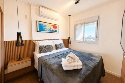 a bedroom with a bed with a towel on it at Noble Studio 22209, Piscina, Vaga, Academia, Ar in Guarulhos
