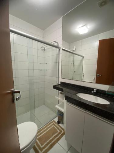 a bathroom with a toilet and a sink and a mirror at Monte Castelo Flat in Sairé