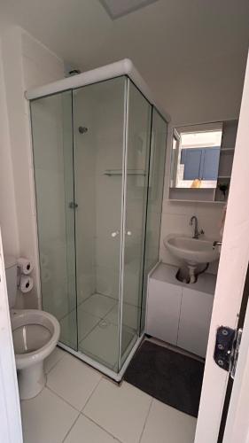 a bathroom with a glass shower and a sink at Studio com sacada, piscina e academia a 25 min Aeroporto GRU in São Paulo
