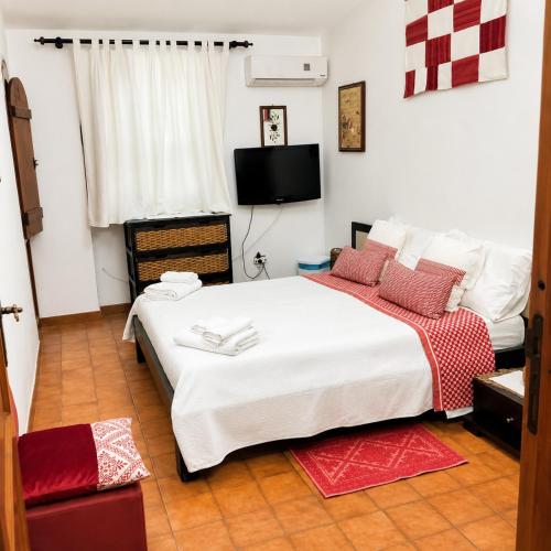 a bedroom with a large white bed with red pillows at Daddos in Flumini di Quartu