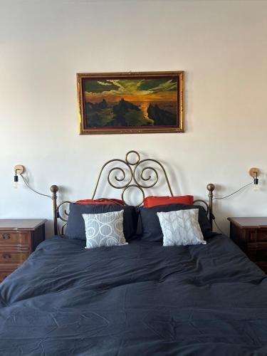 a bedroom with a blue bed with a picture on the wall at 120 mq trilocale e terrazzo in Moncalieri