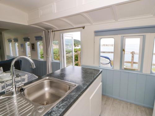 a kitchen with a sink and a counter top at Clifftop Carriage in Aberporth